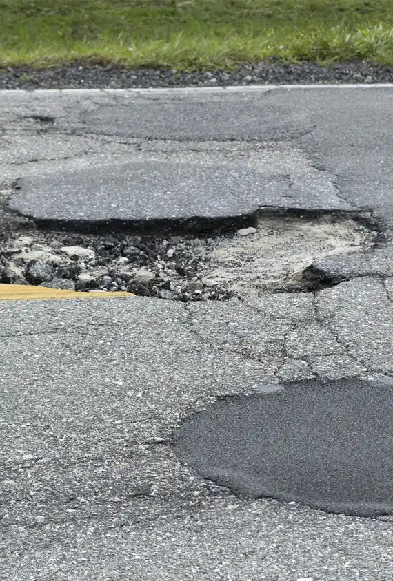 damaged american road surface with deep pothole ruined street in urgent need of repair